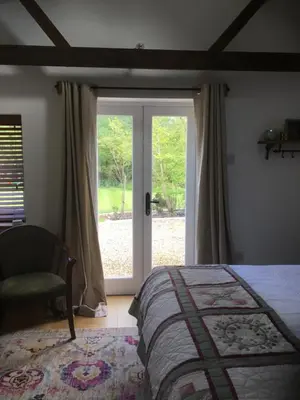 a bedroom with a bed and a sliding glass door at Garden View in Saxlingham Thorpe