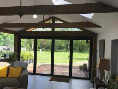a living room with a large glass door to a golf course at Garden View in Saxlingham Thorpe