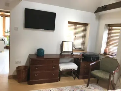 an office with a desk and a television on a wall at Garden View in Saxlingham Thorpe
