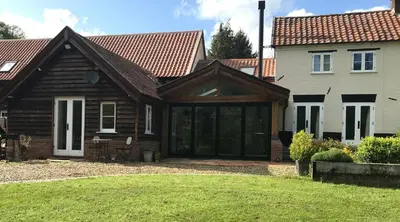 a house with a large sliding glass door at Garden View in Saxlingham Thorpe
