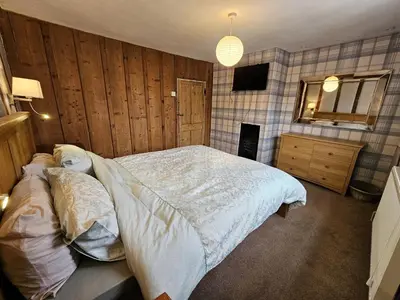 a bedroom with a large bed and a television at Perfectly Located Pretty Cottage in Diss