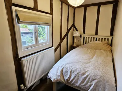a bedroom with a bed and a window at Perfectly Located Pretty Cottage in Diss