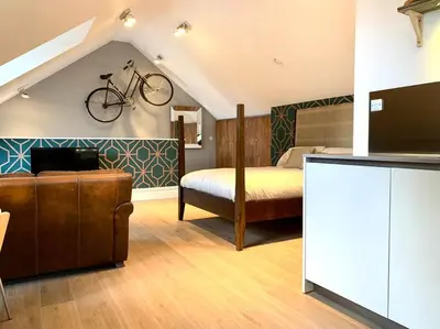 a bedroom with a bed and a bike hanging on the wall at Scholar's Loft - Cosy & Close to Central Cambridge in Cambridge