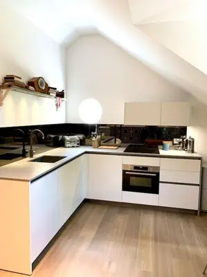 a kitchen with white cabinets and a sink at Scholar's Loft - Cosy & Close to Central Cambridge in Cambridge