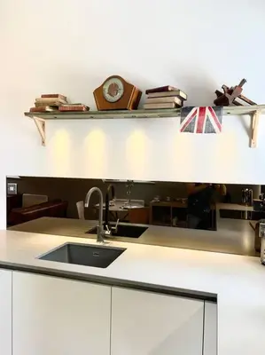 a kitchen with a sink and a clock on a shelf at Scholar's Loft - Cosy & Close to Central Cambridge in Cambridge