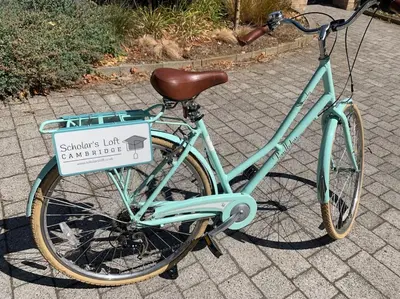 a bike parked on a sidewalk with a sign on it at Scholar's Loft - Cosy & Close to Central Cambridge in Cambridge
