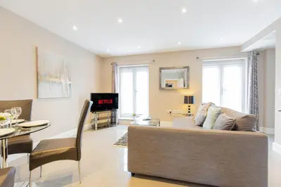 a living room with a couch and a table at Velvet 2-bedroom apartment, Conduit Lane, Hoddesdon in Hoddesdon