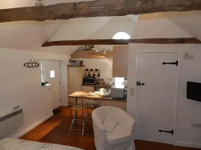 a room with a kitchen with a table and a counter at The Old Dairy, Valley Farm, Middleton in Middleton