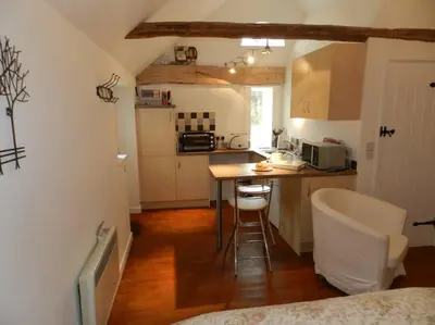 a kitchen with a table and chairs in a room at The Old Dairy, Valley Farm, Middleton in Middleton