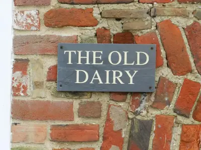 a sign on a brick wall that reads the old dairy at The Old Dairy, Valley Farm, Middleton in Middleton