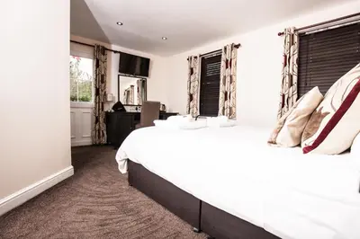 a bedroom with a large white bed and windows at Bridge Hotel Brandon in Brandon