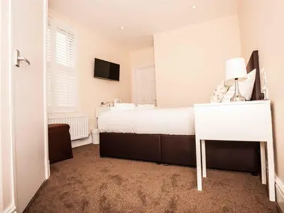 a bedroom with a white bed and a white desk at Bridge Hotel Brandon in Brandon