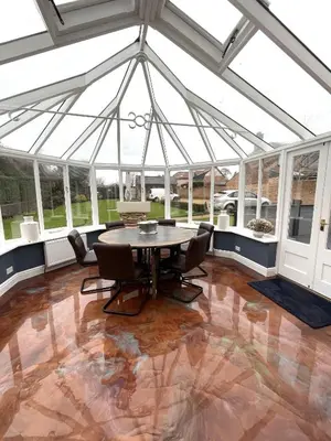 a dining room with a table and chairs in a conservatory at Moulton Lawn House B&B in Moulton