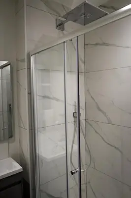 a shower with a glass door in a bathroom at Moulton Lawn House B&B in Moulton