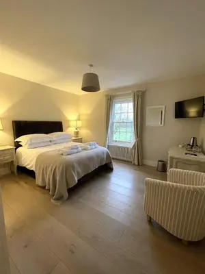 a bedroom with two beds and a window at Moulton Lawn House B&B in Moulton