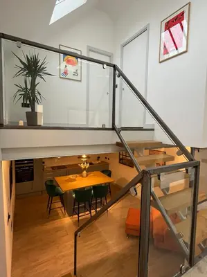 a staircase leading up to a living room with a table at Emery Street Lodge in Cambridge