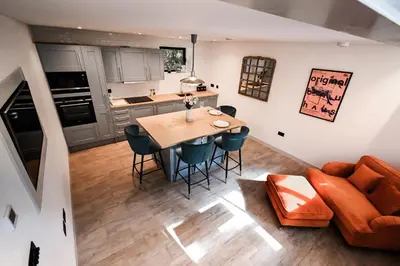a kitchen and living room with a table and chairs at Emery Street Lodge in Cambridge
