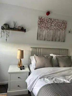 a bedroom with a bed and a table with a lamp at Isabella Rooms in Hockley