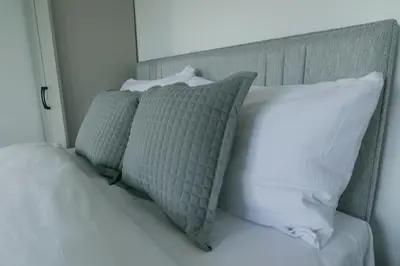 a bed with white sheets and pillows on it at Isabella Rooms in Hockley