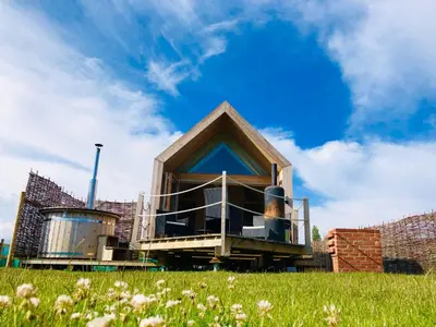 a house on top of a field of grass at Lushna 1 Mezzanine at Lee Wick Farm Cottages & Glamping in Clacton-on-Sea