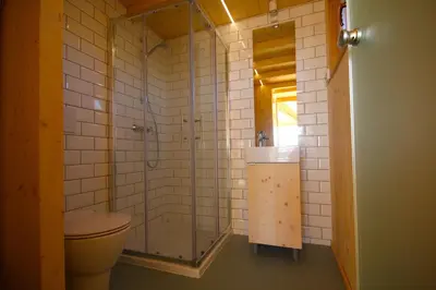 a bathroom with a shower and a toilet and a sink at Lushna 1 Mezzanine at Lee Wick Farm Cottages & Glamping in Clacton-on-Sea