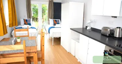 a kitchen and a living room with two beds at 4-5 Bedroom House Garden Lots of Parking 15 min to city Close to motorway in Girton