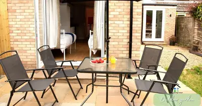 a table and chairs on a patio with a bowl of fruit at 4-5 Bedroom House Garden Lots of Parking 15 min to city Close to motorway in Girton