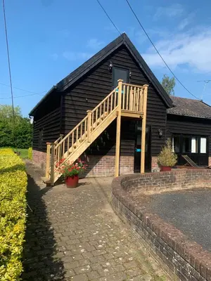 a house with a wooden staircase in front of it at Owls Nest - Peace and Tranquility near Woodbridge & Framlingham in rural Suffolk in Woodbridge