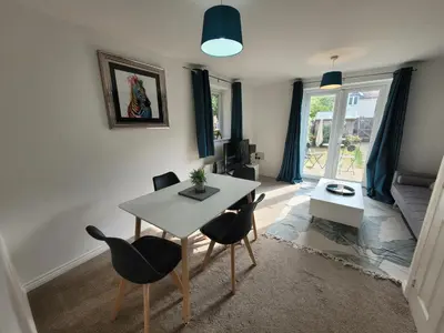 a living room with a table and chairs at Kensington House- The Perfect home for contractor stays in Colchester