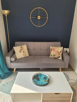 a living room with a couch and a clock on the wall at Kensington House- The Perfect home for contractor stays in Colchester