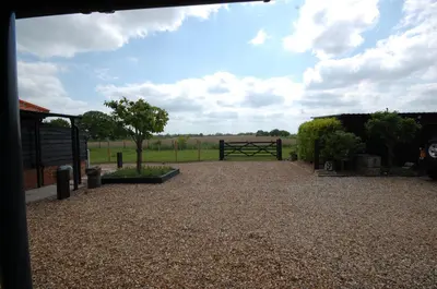 a gravel driveway with a gate and a field at The Retreat Field View in Little Maplestead