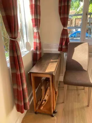 a table and a chair in front of a window at The Cabin in Hockham