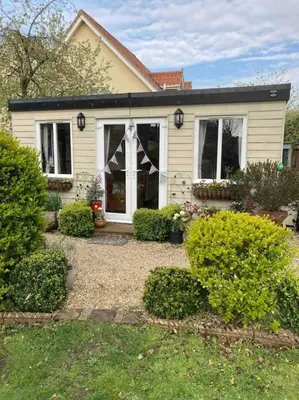 a house with a cross on the front door at The Cabin in Hockham