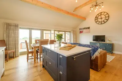 a kitchen and living room with a couch and a table at Alde Bay Farm - Lobster Pot in Aldeburgh