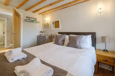 a bedroom with a large white bed with towels on it at Alde Bay Farm - Lobster Pot in Aldeburgh