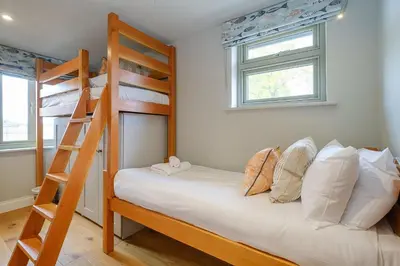 a bedroom with two bunk beds and a ladder at Alde Bay Farm - Lobster Pot in Aldeburgh