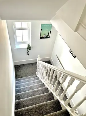 a stairway with a white stair case and a window at High-End 2 Bed Maisonette in Beaulieu Park in Broomfield