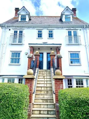 a white house with stairs leading up to a door at High-End 2 Bed Maisonette in Beaulieu Park in Broomfield