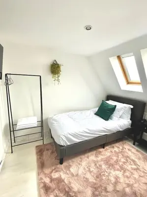 a bedroom with a bed with a mirror and a rug at High-End 2 Bed Maisonette in Beaulieu Park in Broomfield