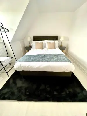 a bedroom with a large bed and a black rug at High-End 2 Bed Maisonette in Beaulieu Park in Broomfield