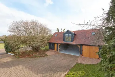 a house with a garage and a driveway at The Lodge Bury St Edmunds in Bury Saint Edmunds
