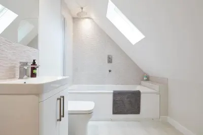 a white bathroom with a sink and a toilet at The Lodge Bury St Edmunds in Bury Saint Edmunds