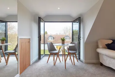 a dining room with a table and chairs in a house at The Lodge Bury St Edmunds in Bury Saint Edmunds