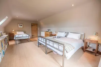 a bedroom with a large bed and a desk at Gardiners Cottage Barn, Braiseworth in Eye
