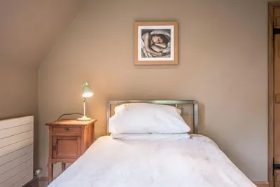 a bedroom with a bed and a picture on the wall at Gardiners Cottage Barn, Braiseworth in Eye