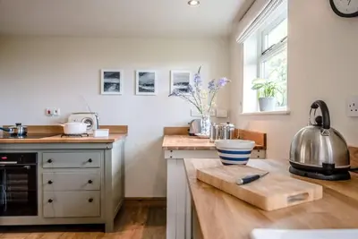 a kitchen with a counter top with a kettle on a table at Gardiners Cottage Barn, Braiseworth in Eye