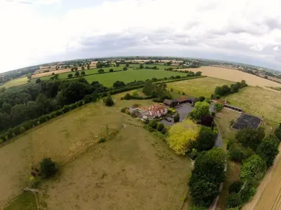 an aerial view of a house in a field at Paddock Barn ~ Short & Long term stay, pets welcome ~ Woodbridge, Framlingham ar in Cretingham