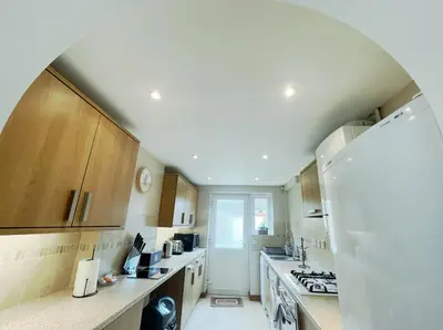 a kitchen with wooden cabinets and a white refrigerator at Tree View Apartment in Chesterton