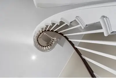 a metal spiral staircase with a wooden handle at 119 Flat 2 Northgate st - Stylish one bedroom apartment set within walking distance to town, spacious living space with public car park close by in Bury Saint Edmunds