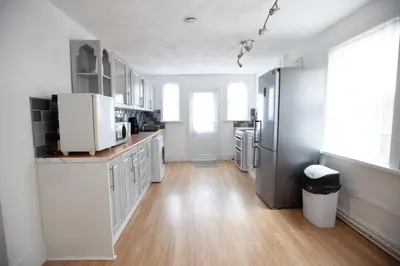 a kitchen with white appliances and a wooden floor at Beach palace in Clacton-on-Sea